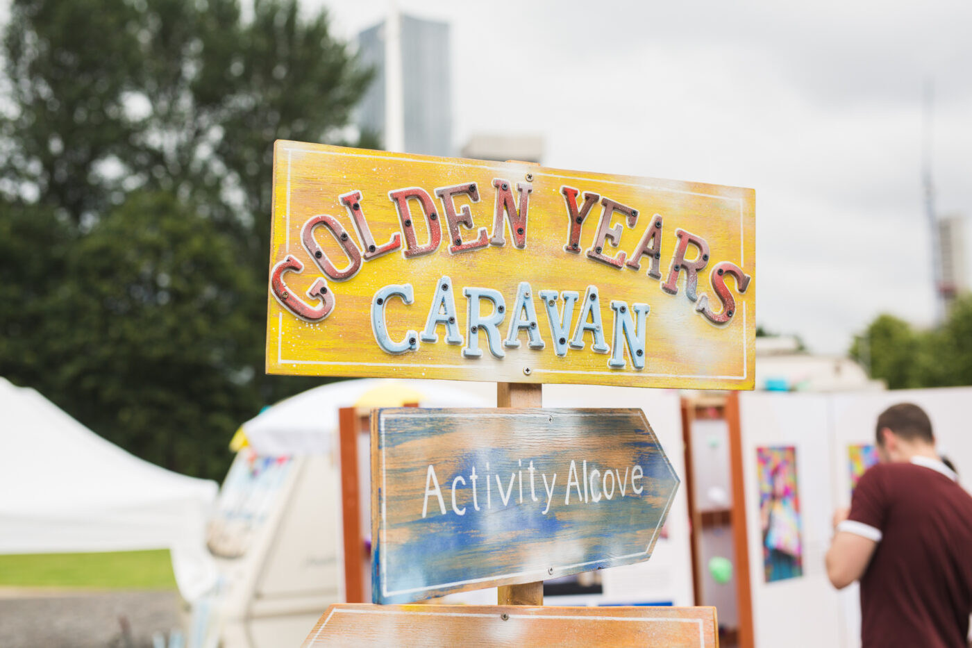 A yellow signpost reads Golden Years Caravan at the top, with an arrow underneath pointing the way to activity alcove.