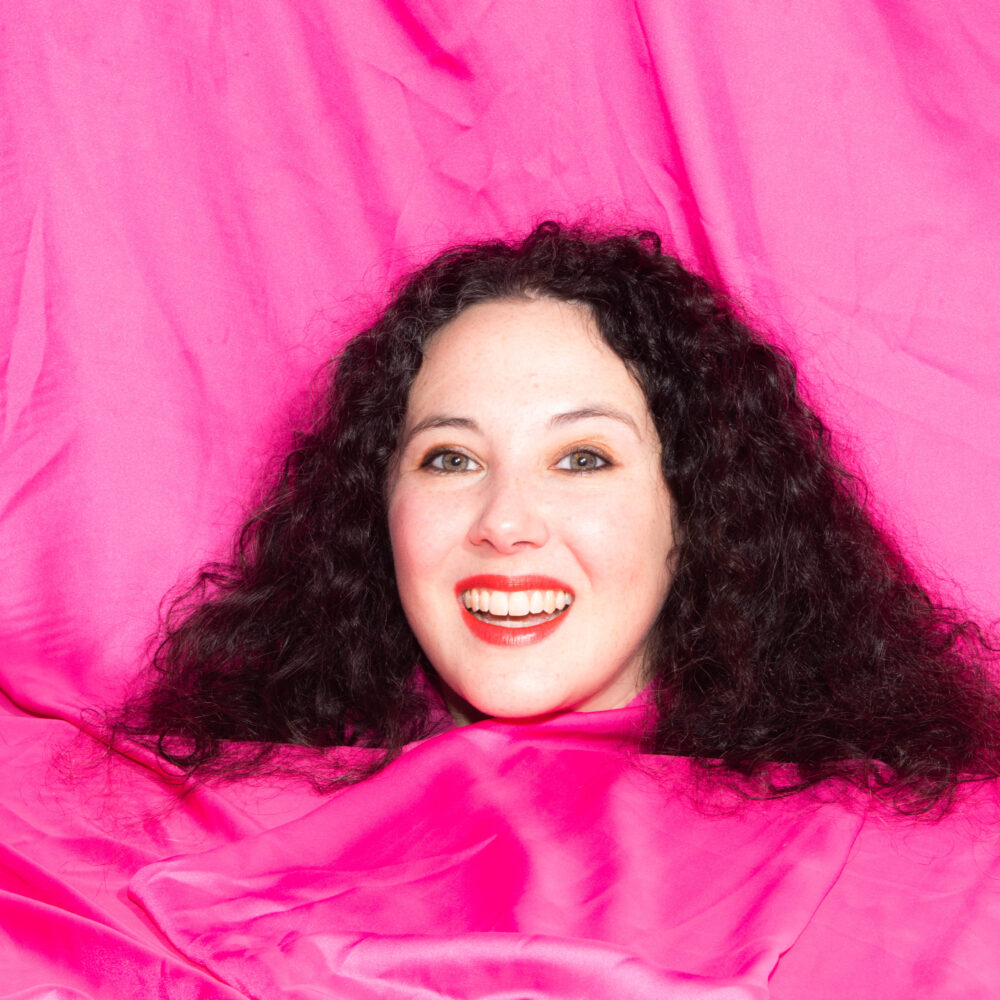 Headshot of Jenny Gaskell with a silk pink backdrop.