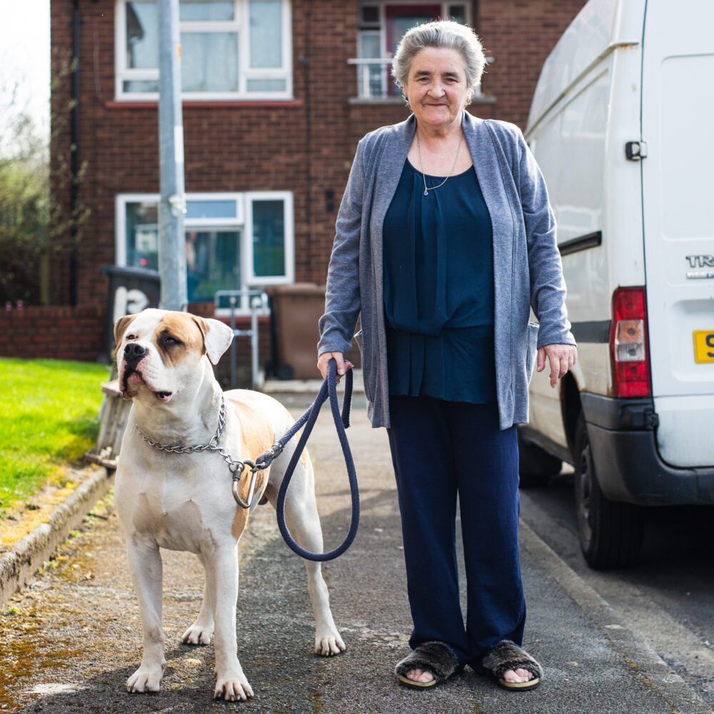 Photo of participant Janice stood on her street with her dog