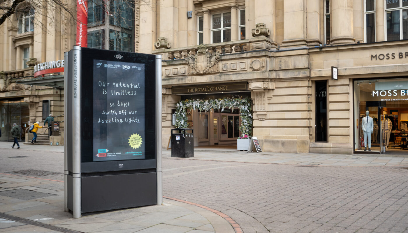 'Our potential is limitless so don't switch off our dazzling lights' is written in children's handwriting on a billboard in Exchange Square, Manchester.