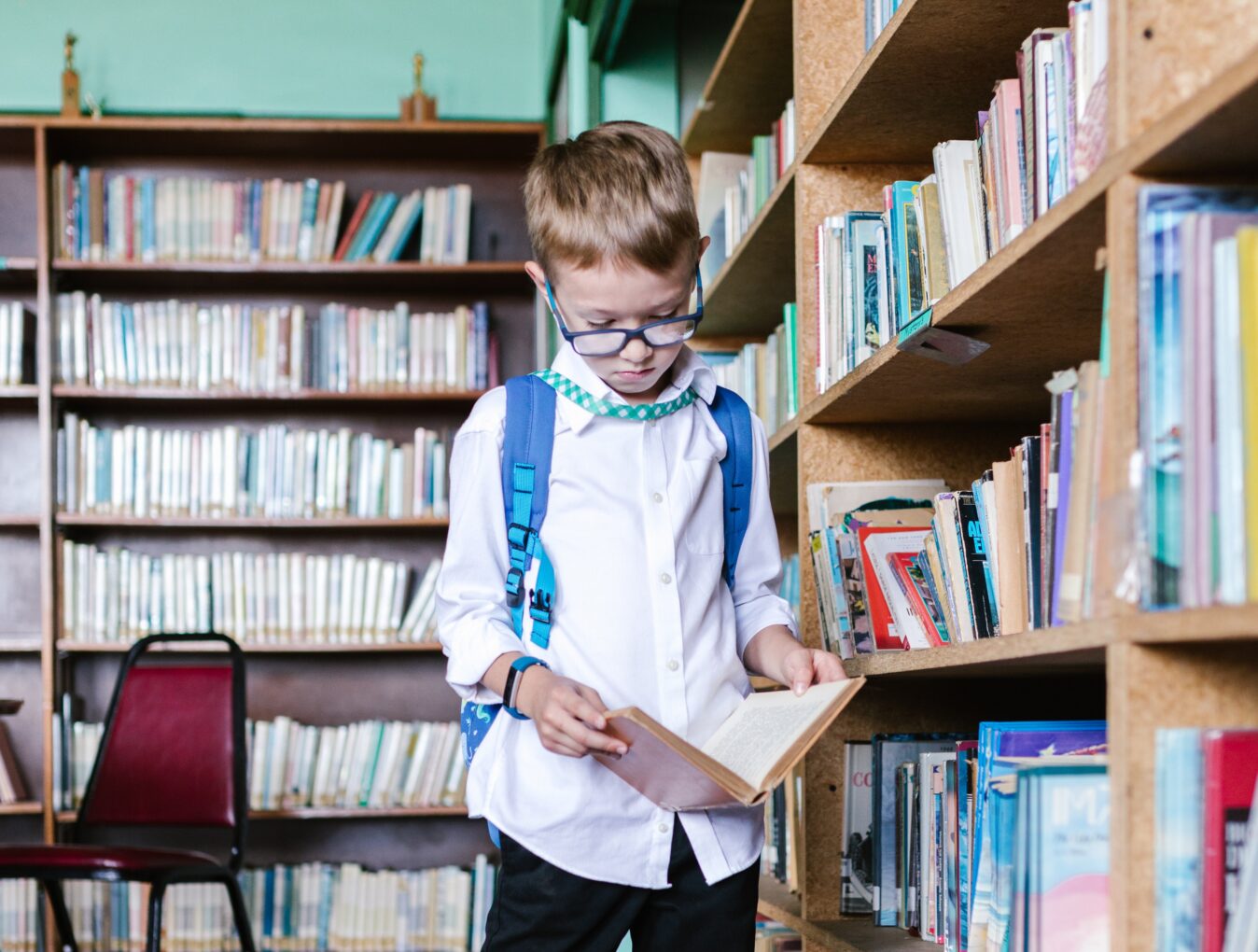 A school child is engrossed in a book in a school library.