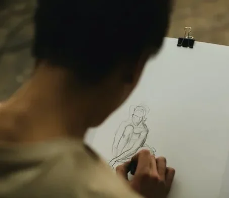 A person sketching a human figure 