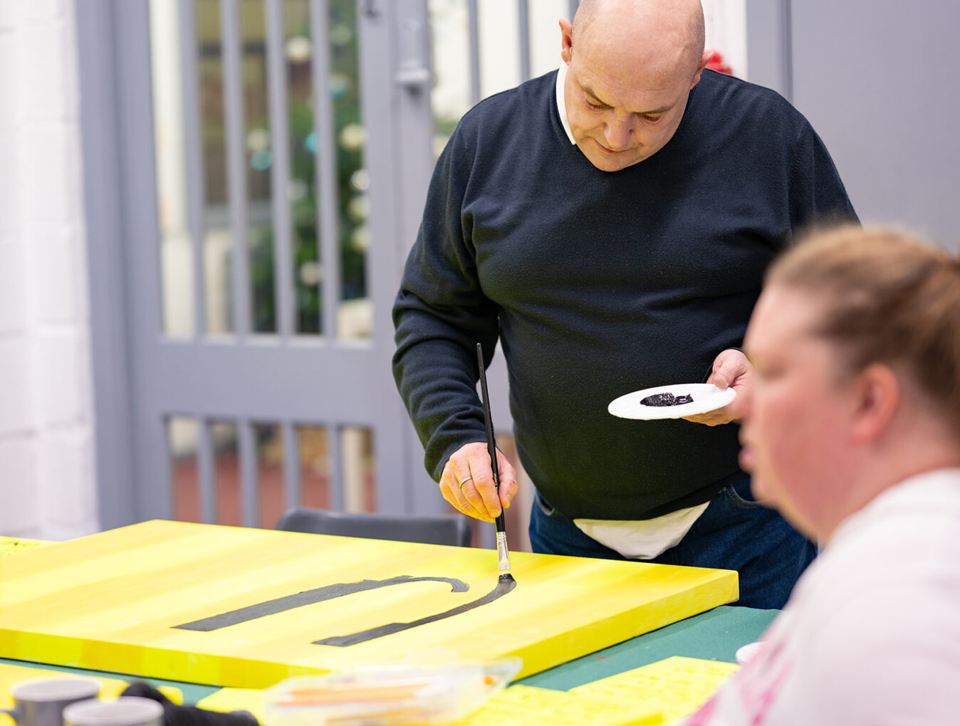 Community collaborator paints during a workshop