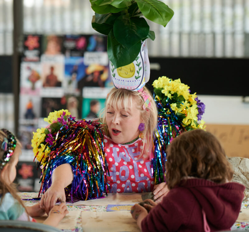 A photo of Phoebe doing a workshop while wearing brightly coloured clothes