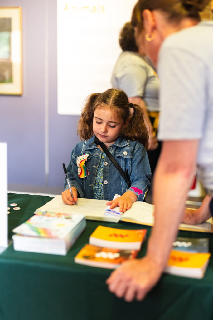 A child signing the salford centenary book