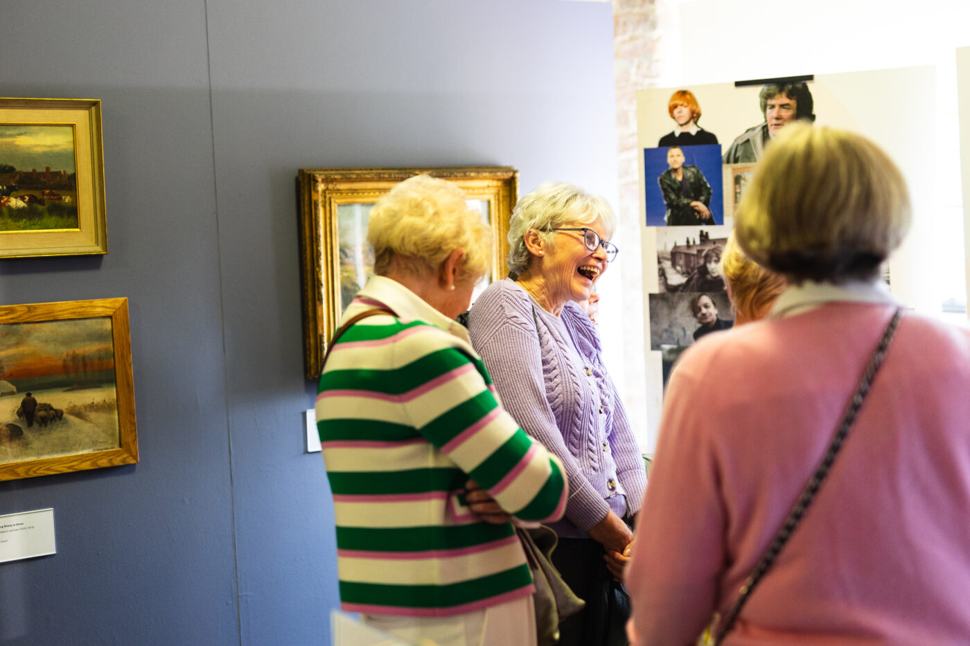 Two older people laughing at the Salford display board