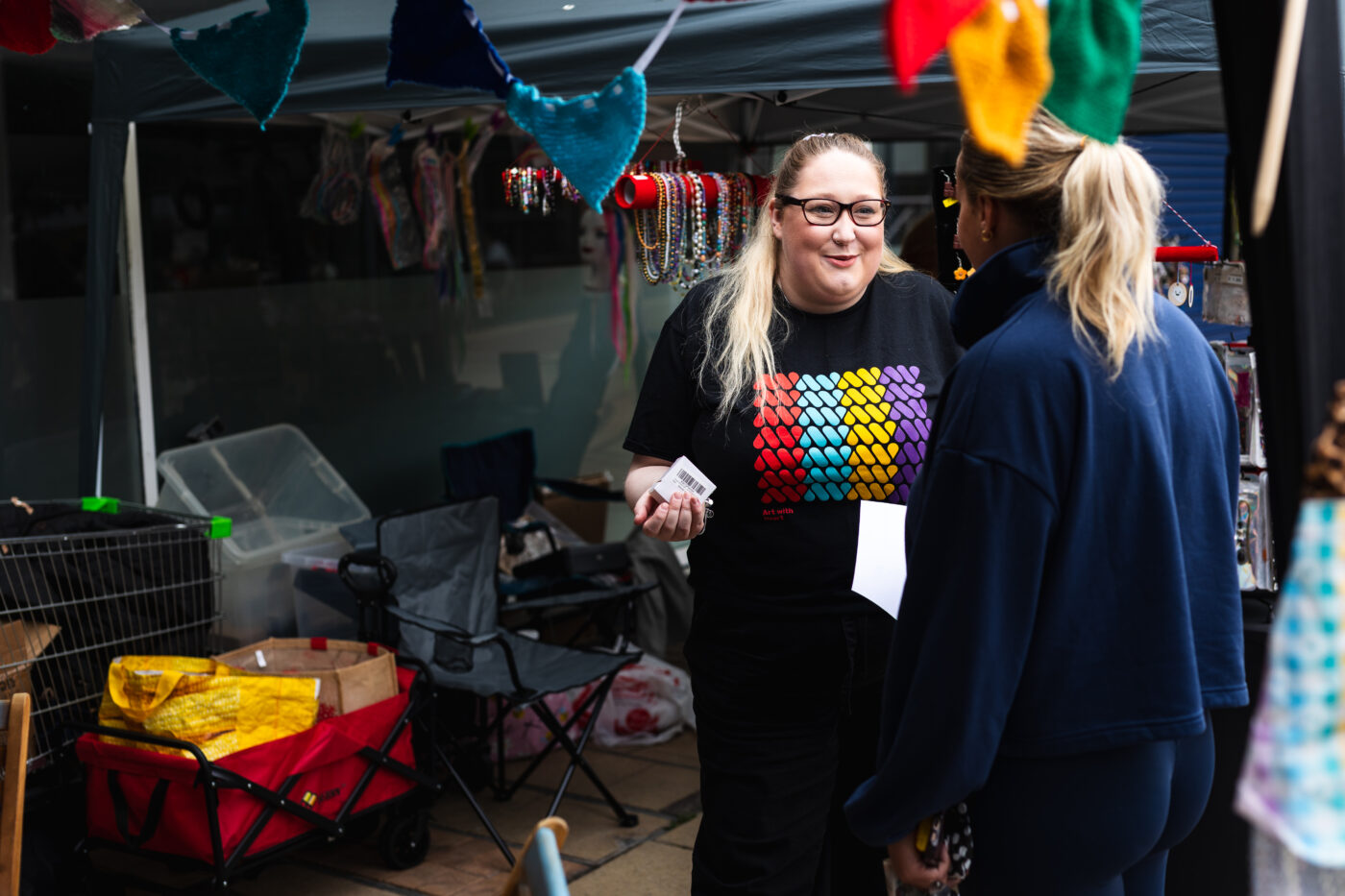 A facilitator welcoming someone to the stand