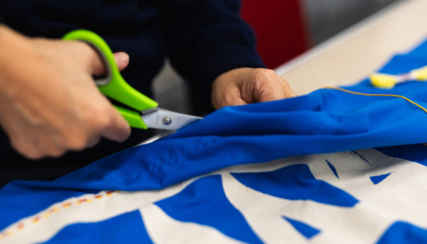 A participant trims a banner with scissors