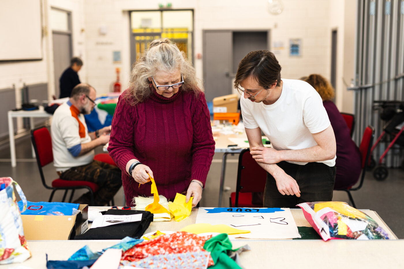 Artist Chris and community collaborator Bev select fabrics for their banner