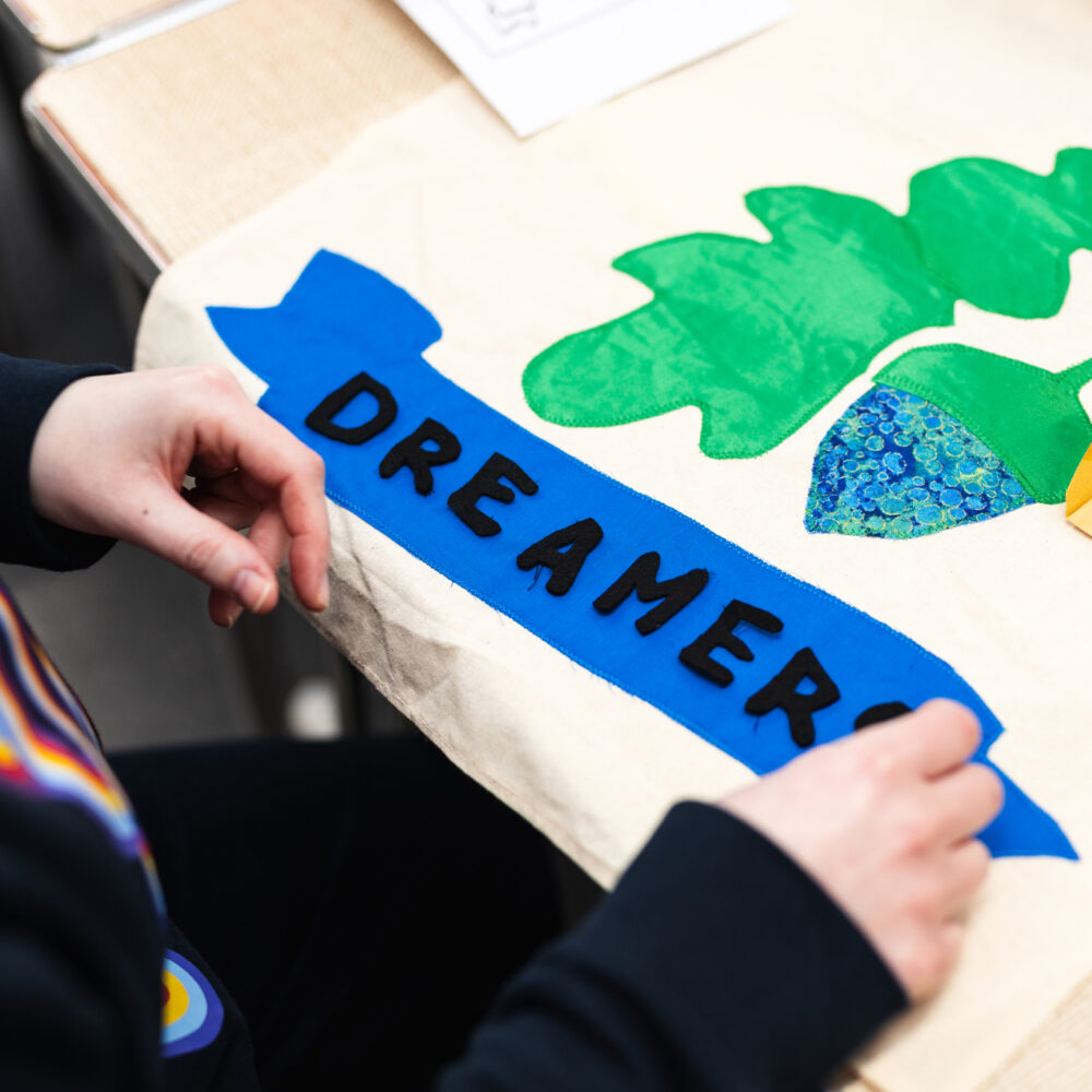A participant places letters on a small banner