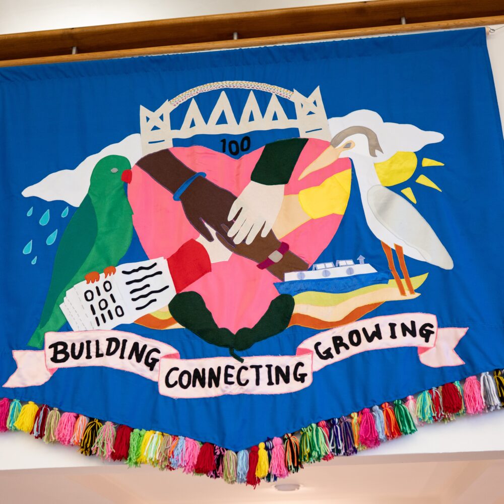 A large blue banner, a reimagined coat of arms for the city of Salford