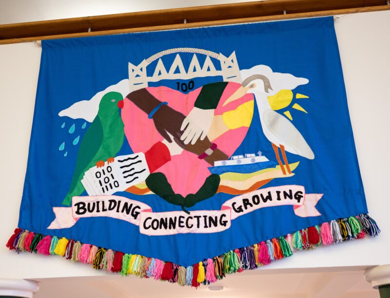A large blue banner, a reimagined coat of arms for the city of Salford