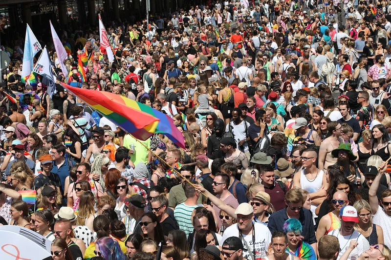 An image of a LGBTQ+ march in Manchester with a large crowd.