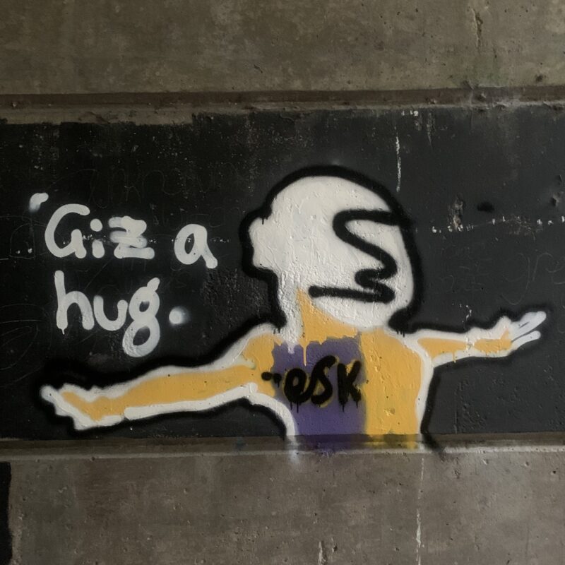 Graffiti artwork reading 'Giz a hug'