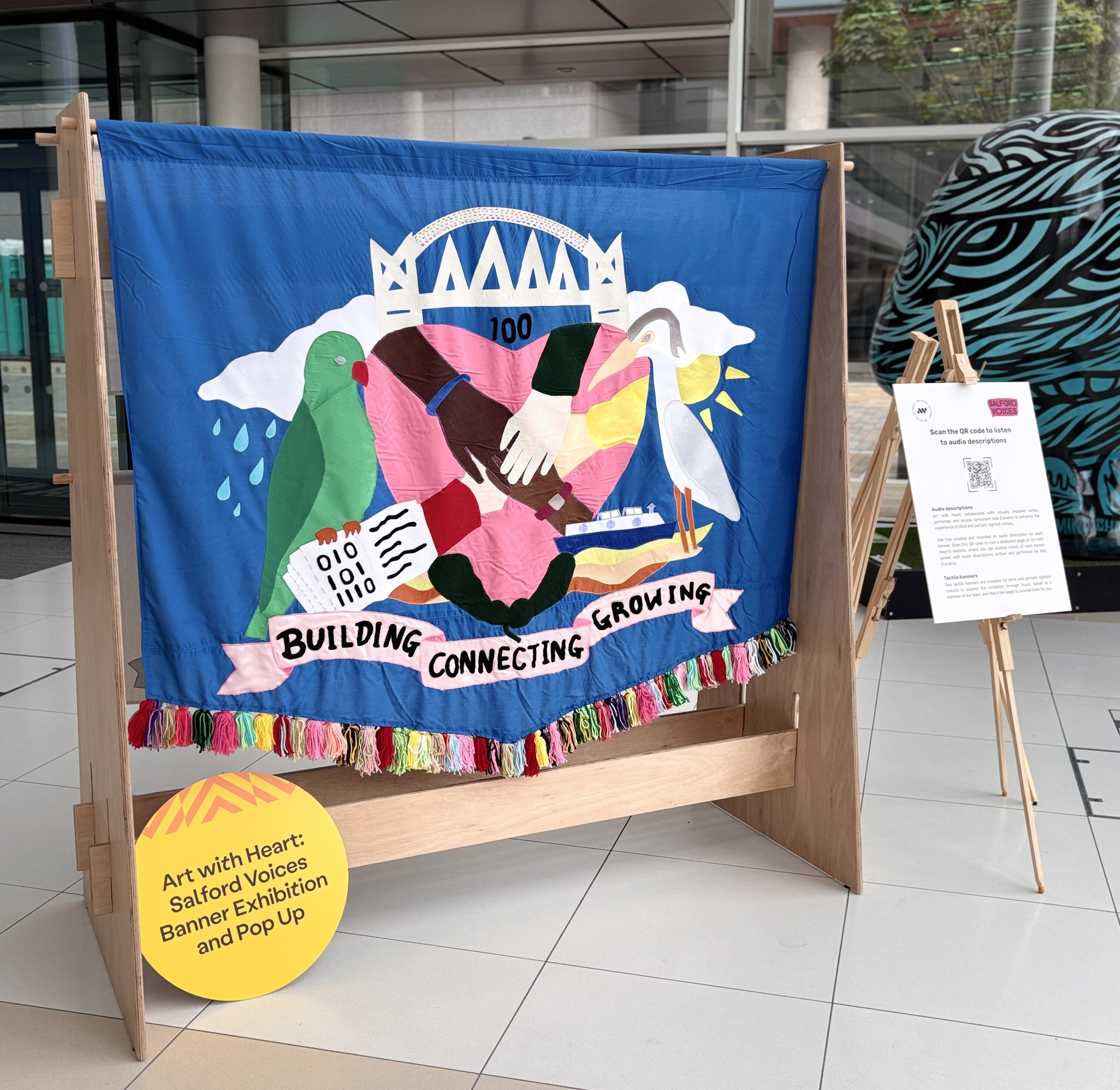 Salford Voices banner is displayed on a wooden exhibition stand
