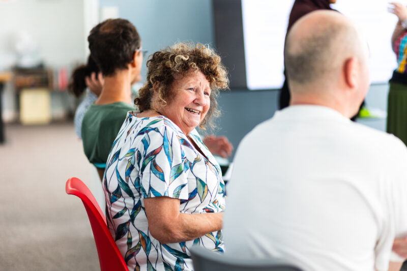 A woman laughing during a creative workshop